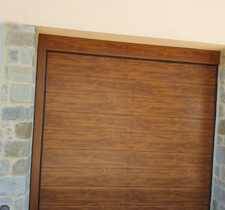 Porta sezionale effetto legno in un vano con contorno in pietra