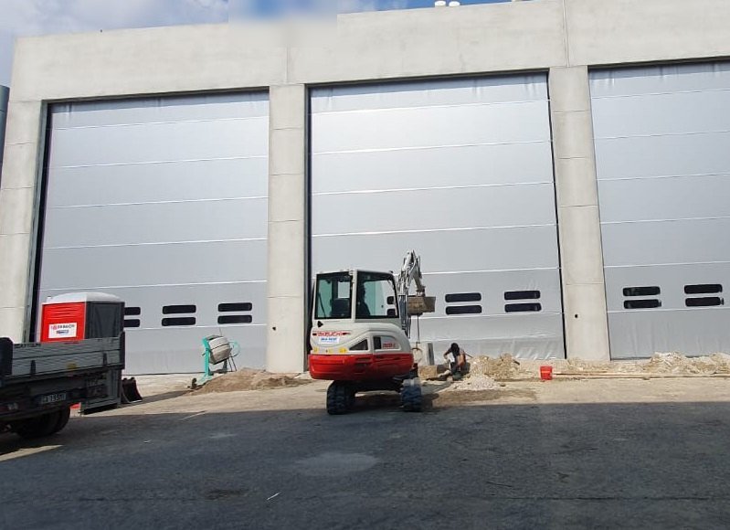 Portoni sezionali industriali con finestrature installati su un capannone
